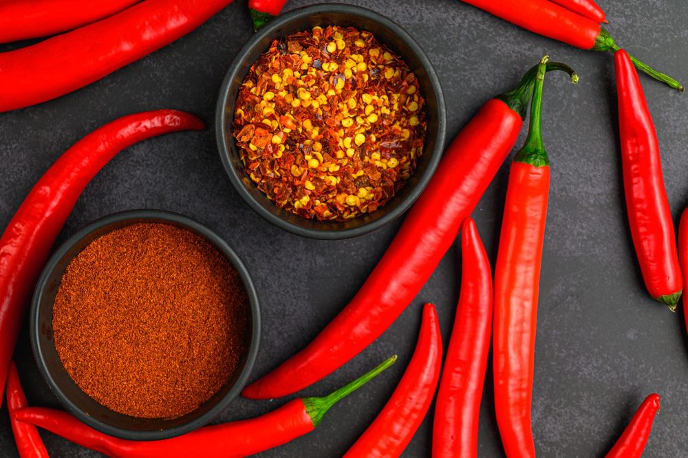 Red chillies with bowls of chilli flakes and powder